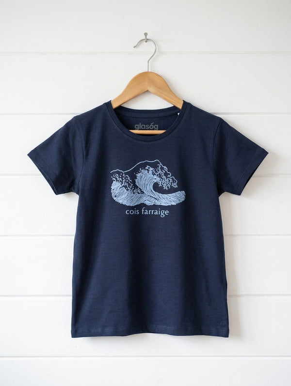 navy kids t-shirt with wave design hanging on wooden shiplap wall
