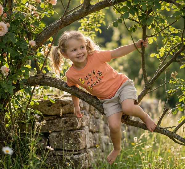 Styled editorial photo of peach kids t-shirt with bee illustration