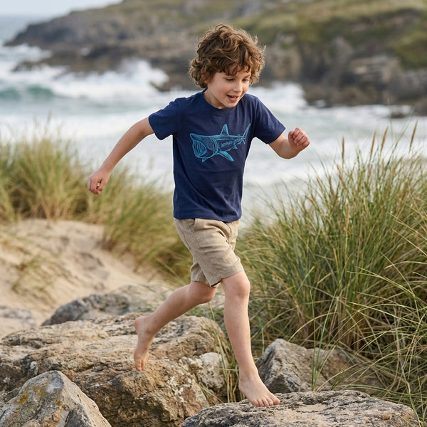 Child in motion wearing blue t-shirt with shark design