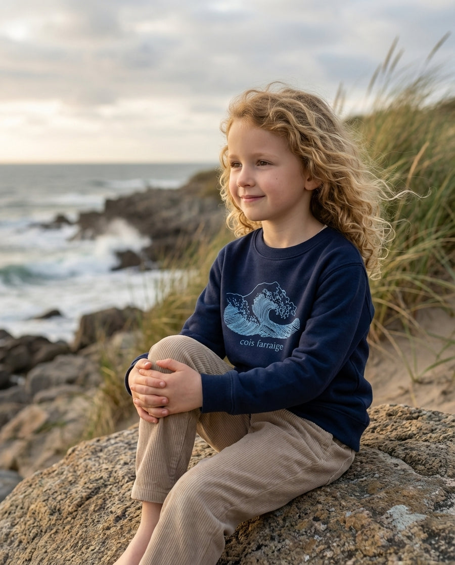 Child wearing navy sweatshirt with wave design, portrait