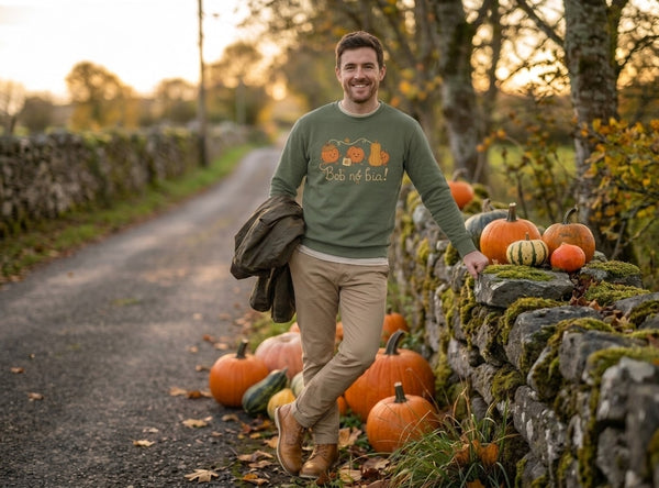 Man wearing the olive Bob nó Bia adult sweatshirt on a country lane lined with pumpkins