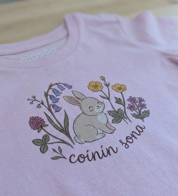 Close-up detail of rabbit-floral illustration on pink t-shirt