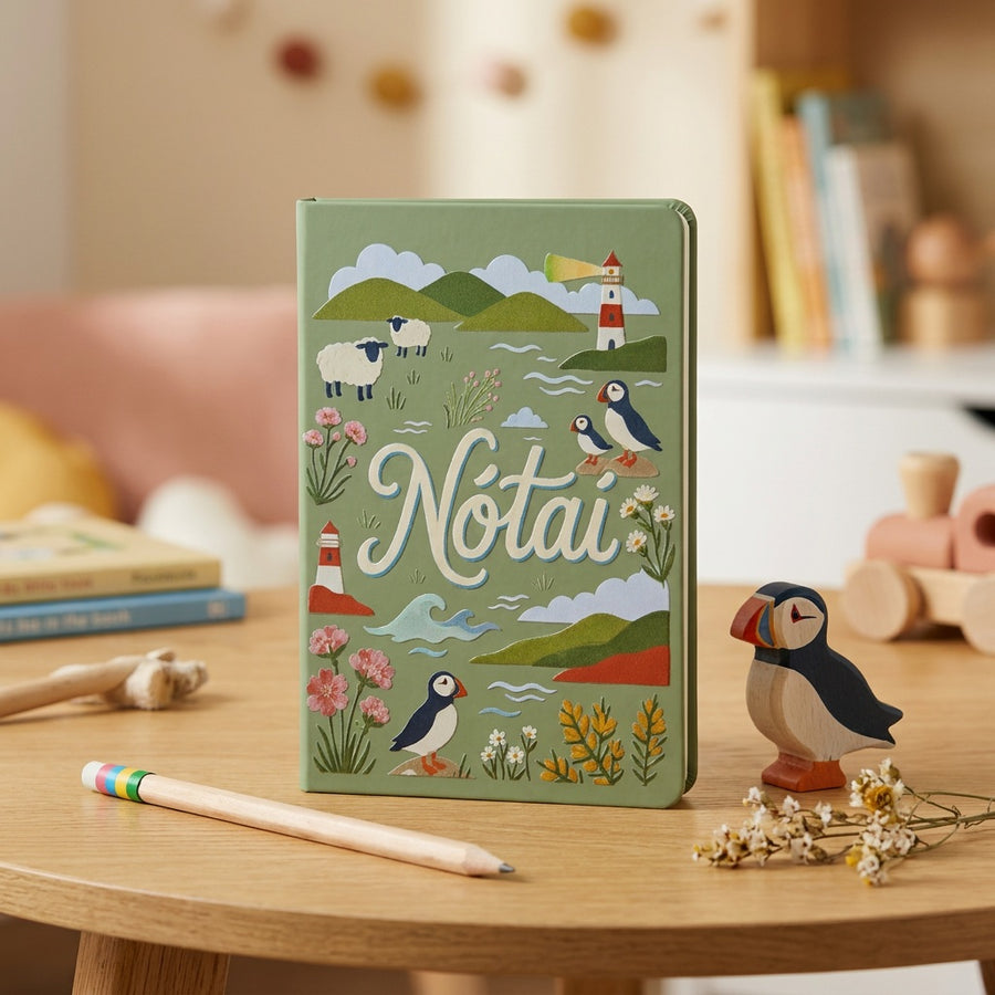 Sage green Nótaí A5 notebook on a table with a wooden puffin, a pencil and dried flowers
