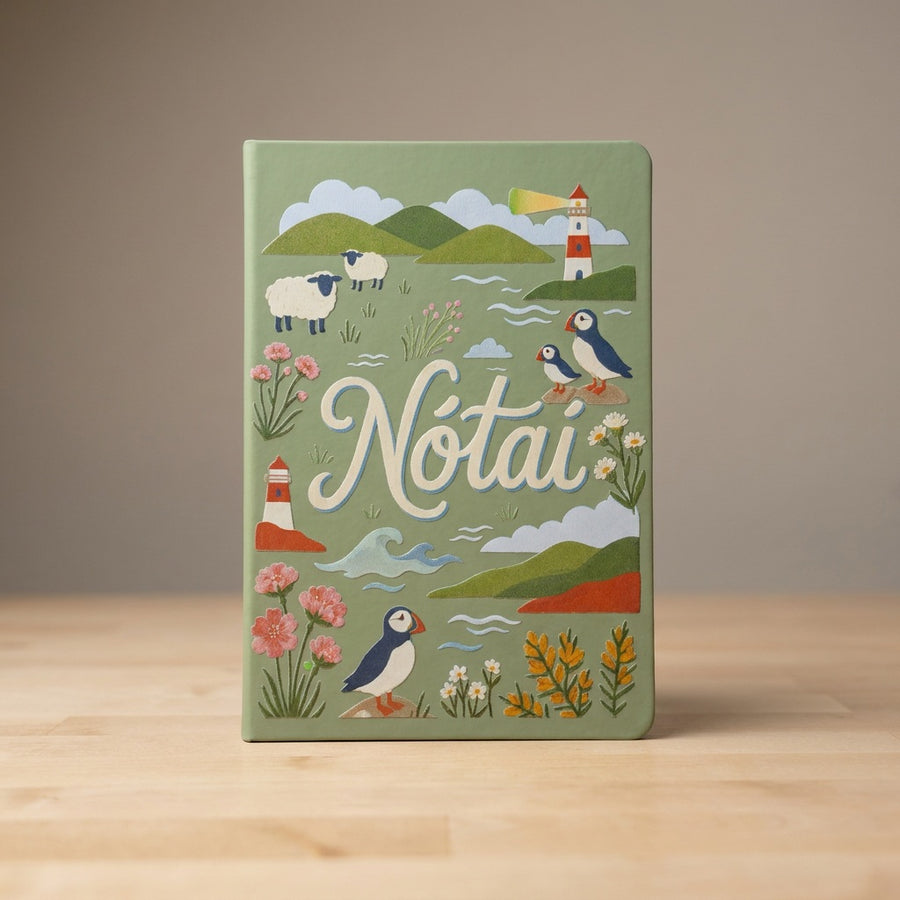 Close-up of the sage green Nótaí cover: puffins, sheep, a lighthouse, sea thrift and gorse