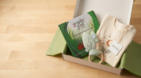 Glasóg woodland gift box packed with an Irish picture book, baby garment and wooden rattle