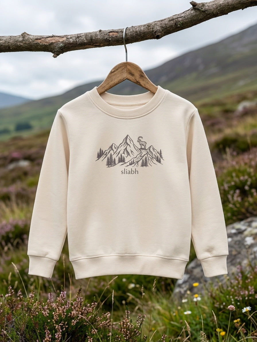 beige kids sweatshirt with mountain design on a wooden hanger outdoors in Irish nature