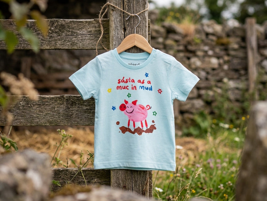 Blue baby t-shirt with pig design on a hanger outdoors