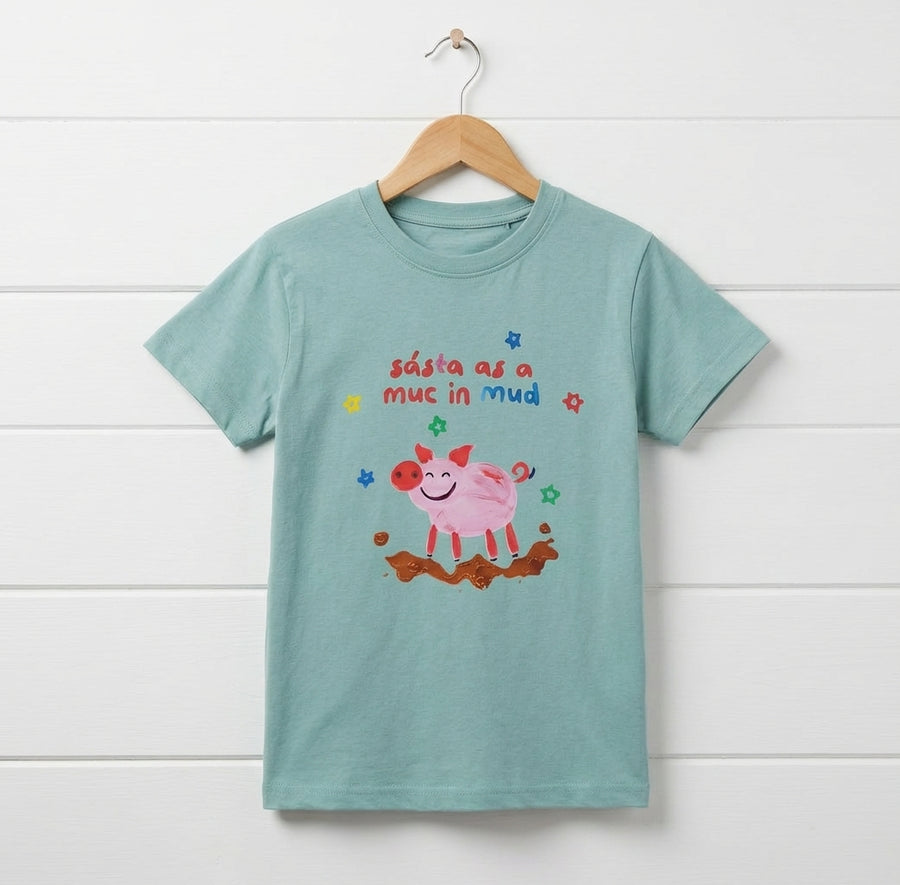 teal kids t-shirt with pig design hanging on wooden shiplap wall