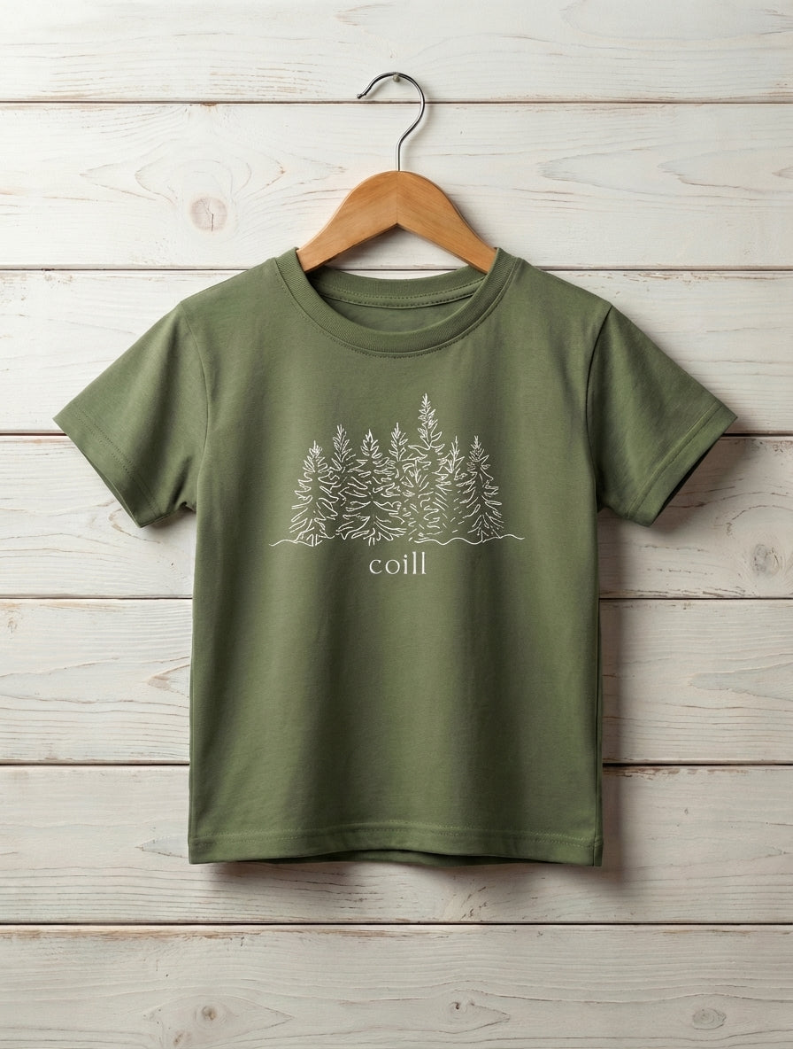 green kids t-shirt with trees design hanging on wooden shiplap wall
