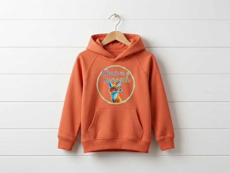 orange kids hoodie with fox design hanging on wooden shiplap wall