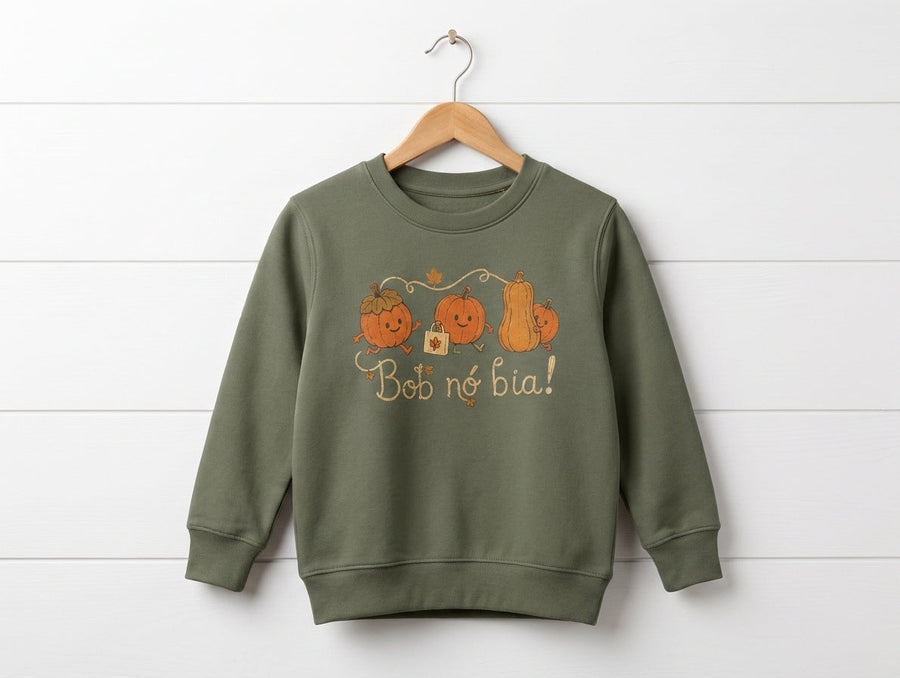 Olive sweatshirt with Bob nó Bia pumpkins design on shiplap wall