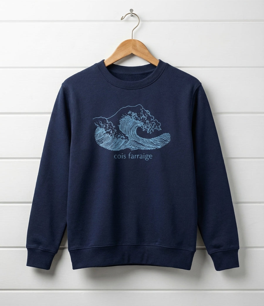 navy sweatshirt with wave design hanging on wooden shiplap wall