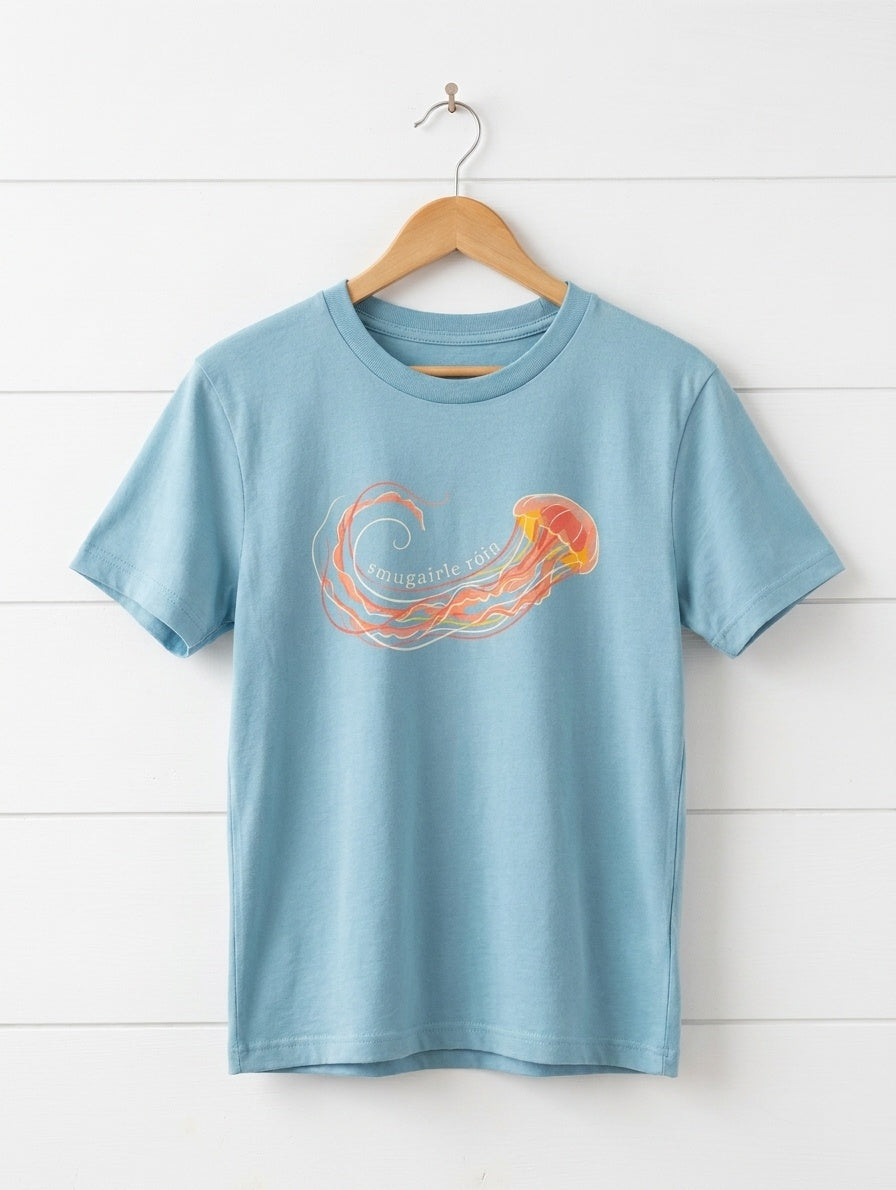 teal kids t-shirt with jellyfish design hanging on wooden shiplap wall