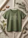 Flat lay of green t-shirt with trees design on natural leaf background