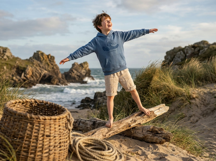 Styled editorial photo of blue kids hoodie with wave illustration