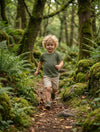 Child in motion wearing green t-shirt with trees design