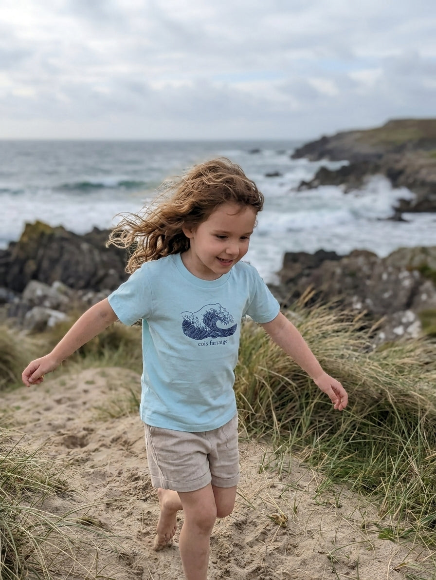 Child in motion wearing poolblue t-shirt with wave design