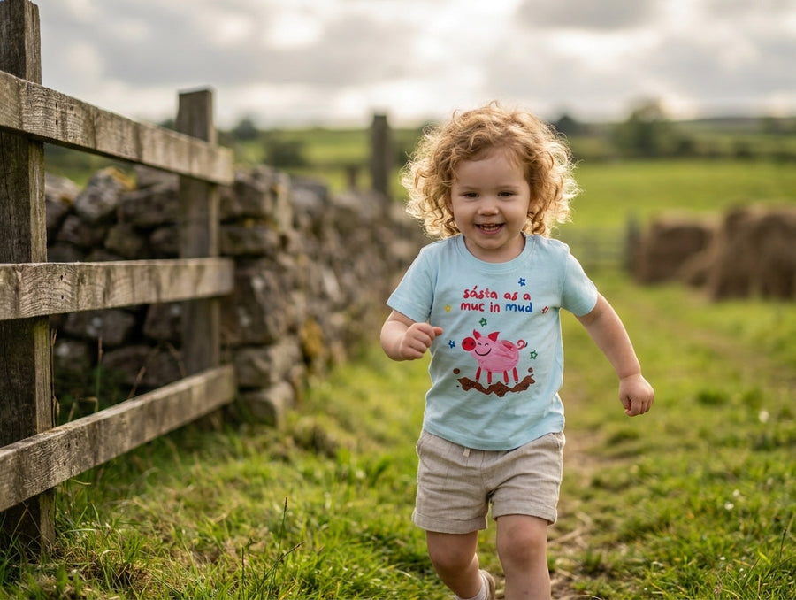 Baby in motion wearing blue organic cotton t-shirt with pig design