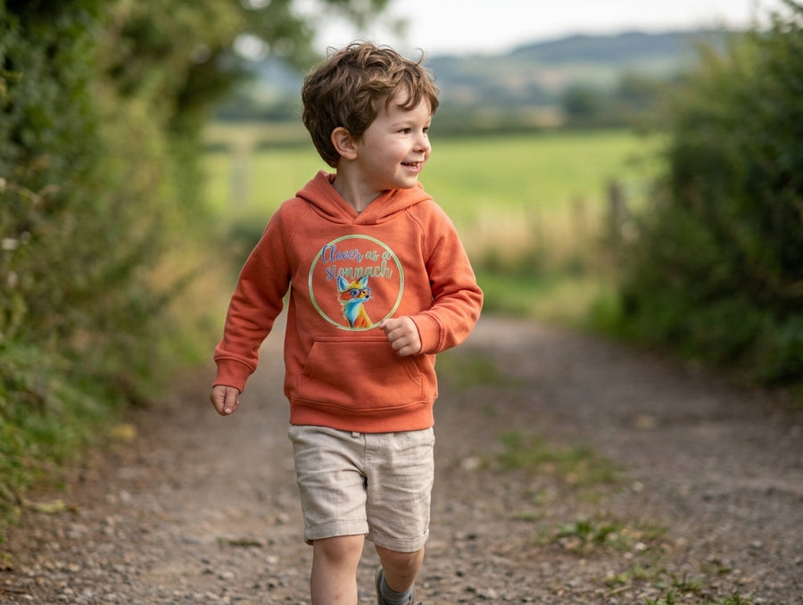 Child in motion wearing orange hoodie with fox design