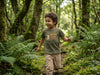 Child in motion wearing olive t-shirt with owl design