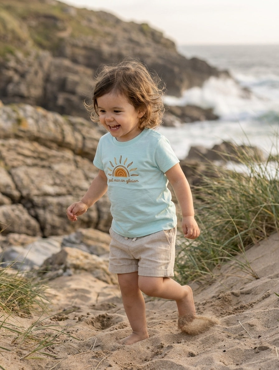 Child in motion wearing blue t-shirt with sun design