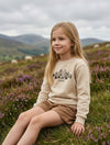 Child wearing beige sweatshirt with mountain design, portrait