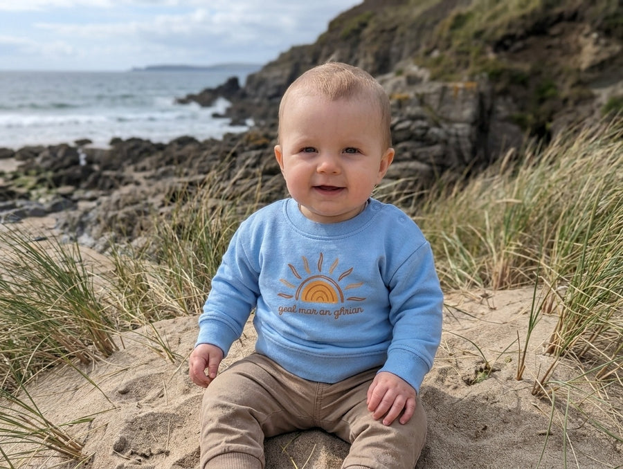 Child wearing blue sweatshirt with sun design, portrait