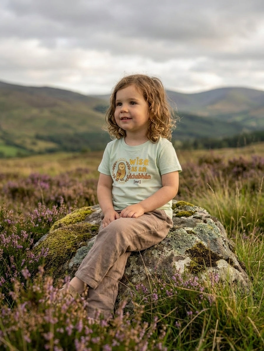 Child wearing seafoam t-shirt with owl design, portrait