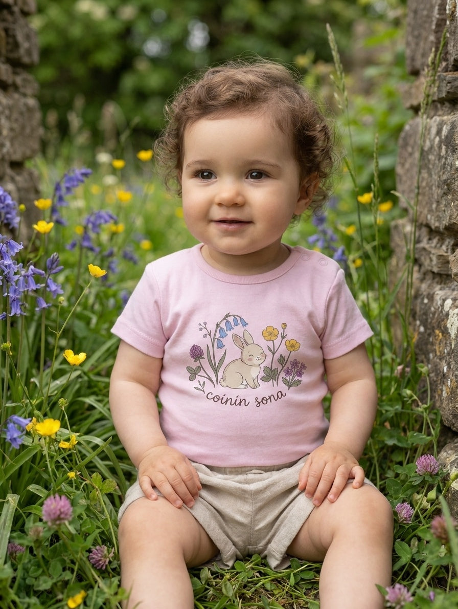 Child wearing pink bodysuit with rabbit-floral design, portrait