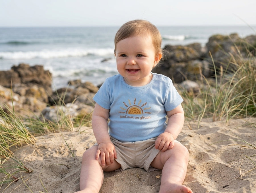 Child wearing blue bodysuit with sun design, portrait