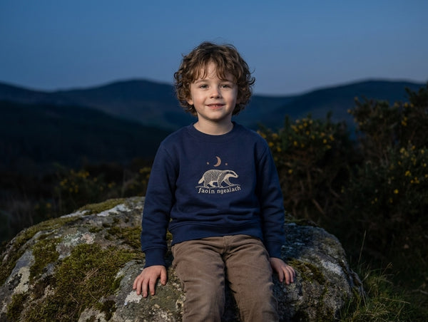 Child wearing navy sweatshirt with faoin-ngealach design, portrait