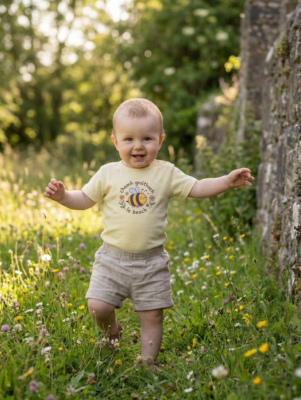 Child wearing butteryellow bodysuit with bee design, portrait