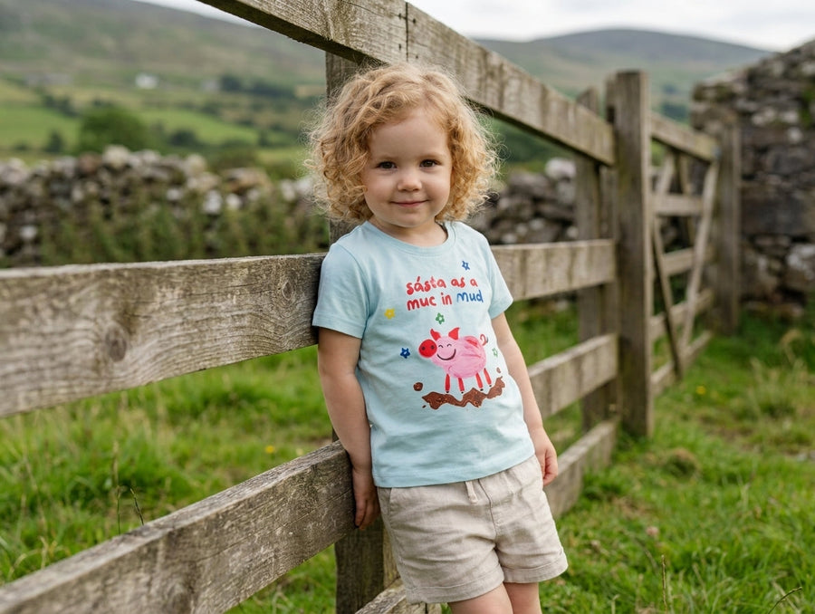 Baby wearing blue organic cotton t-shirt with pig illustration, portrait