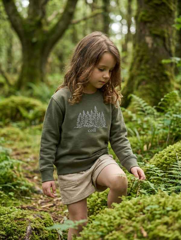 Child wearing olive sweatshirt with trees design, portrait