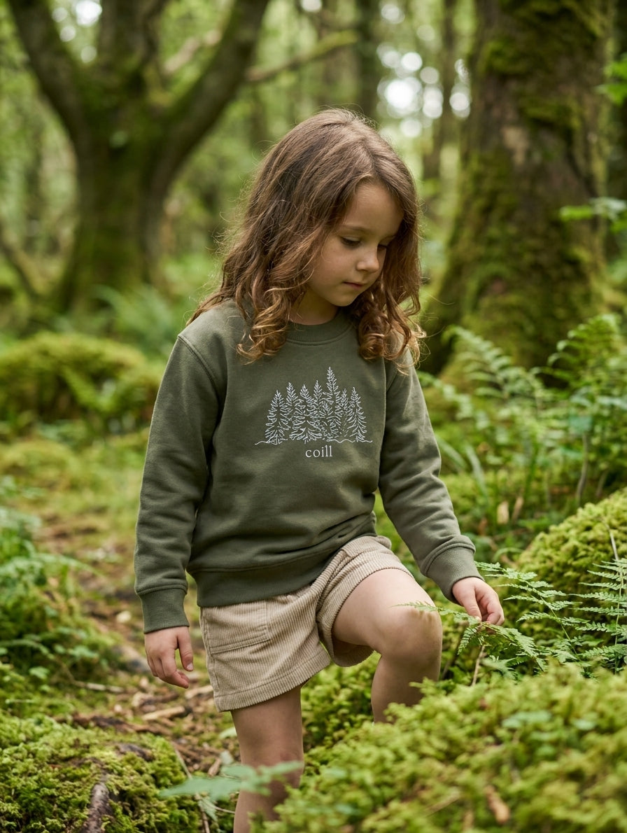 Child wearing olive sweatshirt with trees design, portrait