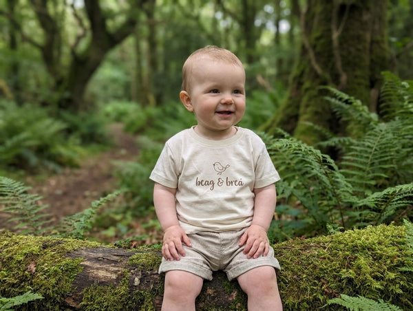 Child wearing oatmeal t-shirt with beagbrea design, portrait