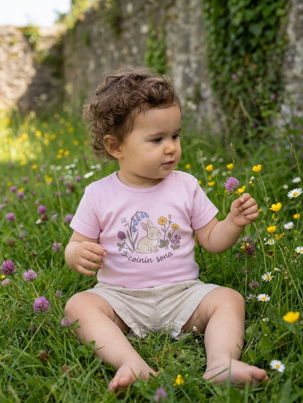 Child wearing pink bodysuit with rabbit-floral design, portrait