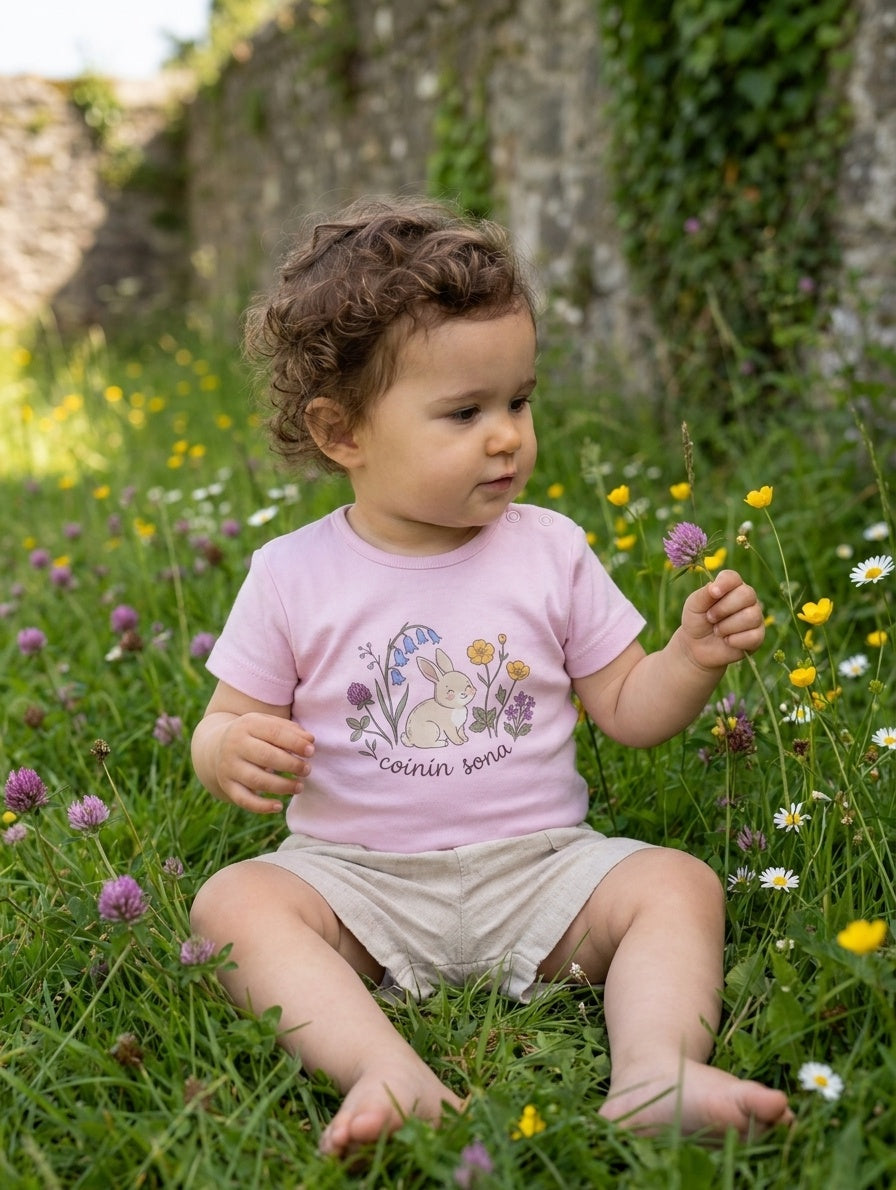 Child wearing pink bodysuit with rabbit-floral design, portrait