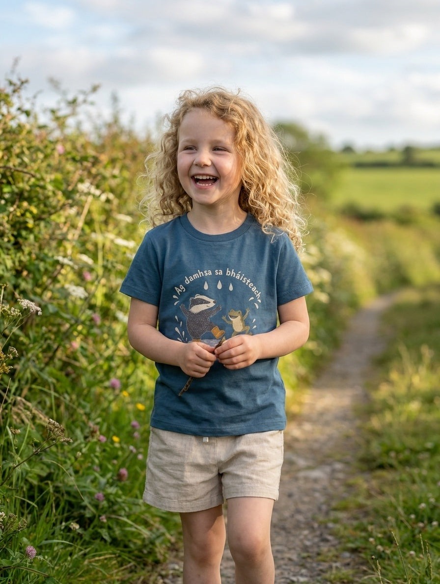 Child wearing twilightblue t-shirt with badger-frog design, portrait