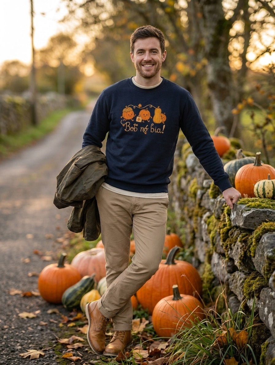 Man wearing the navy Bob nó Bia adult sweatshirt on a country lane lined with pumpkins