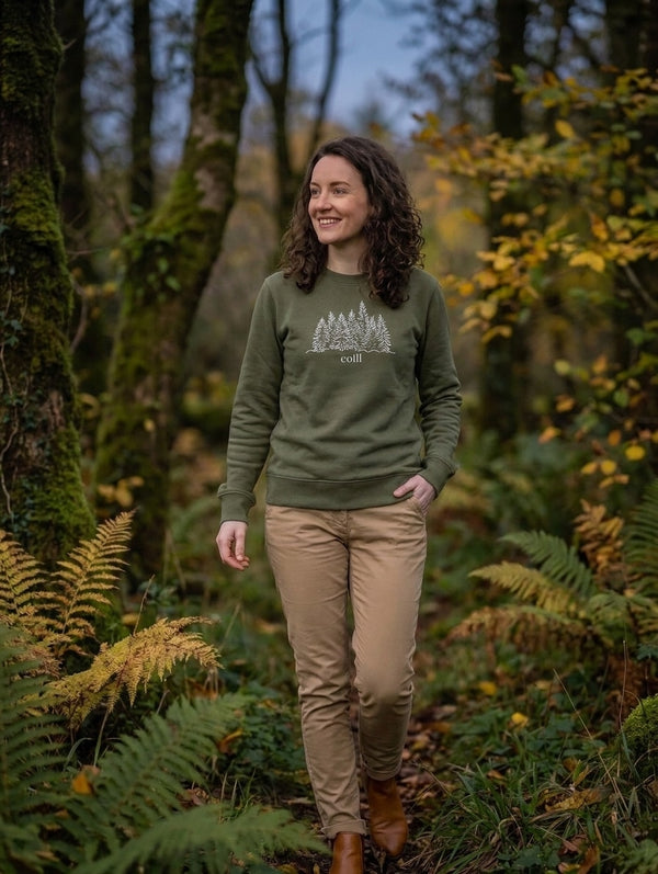 Woman walking through autumn woodland in the olive Coill adult sweatshirt