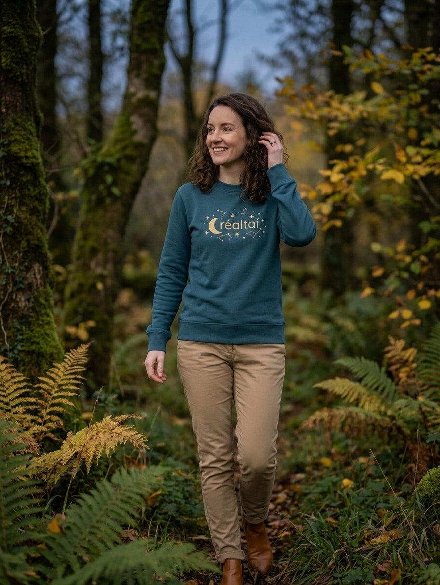 Woman walking through autumn woodland in the twilight blue Réaltaí adult sweatshirt