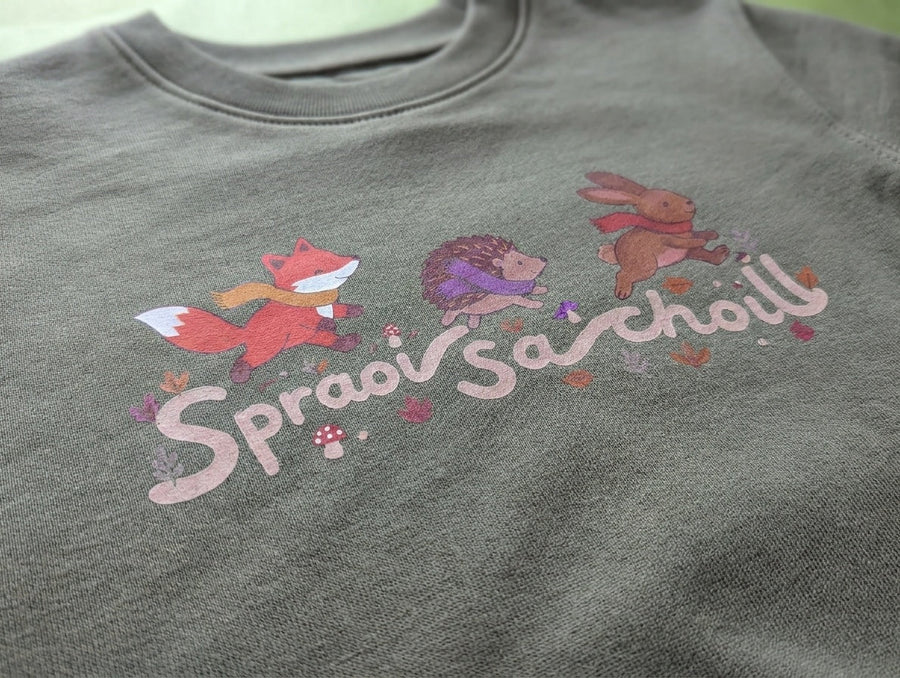 Close-up detail of Spraoi sa Choill design on olive sweatshirt