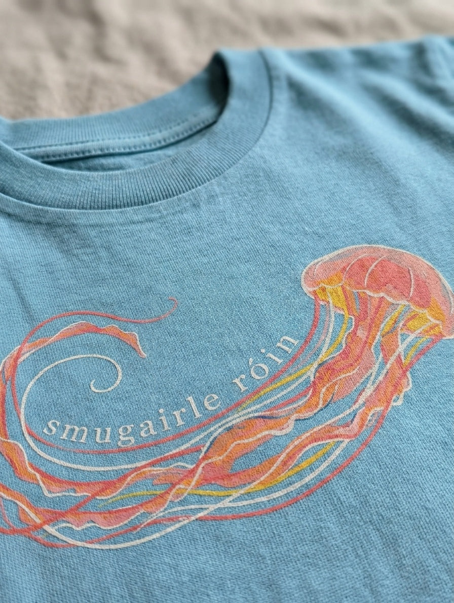 Close-up detail of jellyfish illustration on teal t-shirt
