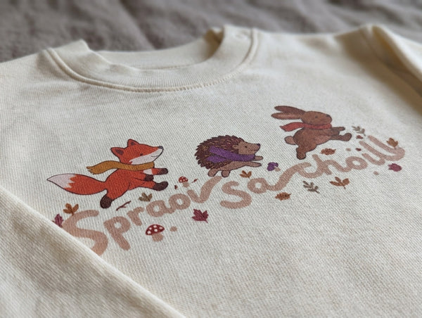 Close-up detail of spraoisachoill illustration on cream sweatshirt