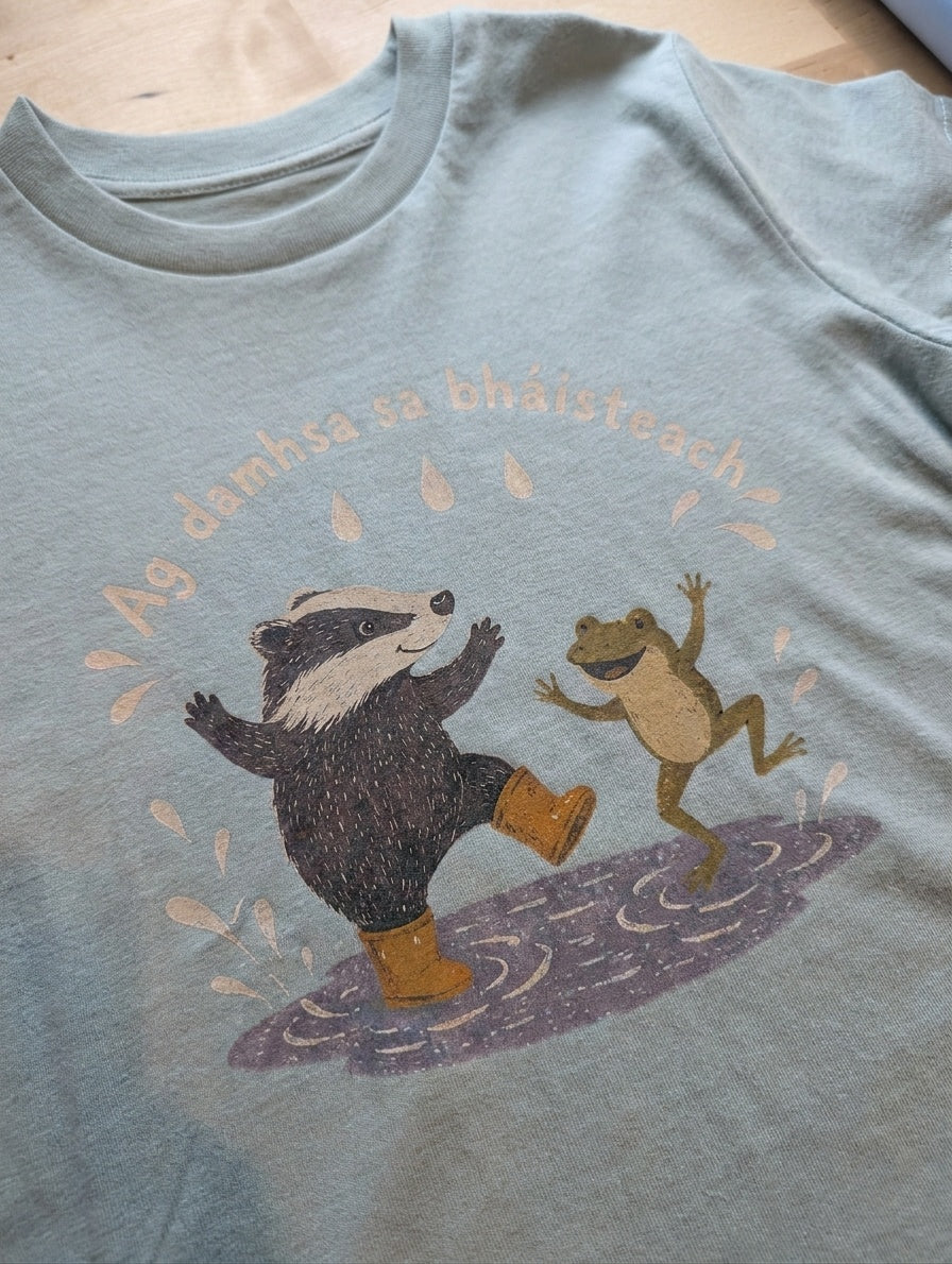 Close-up detail of badger-frog illustration on seafoam t-shirt