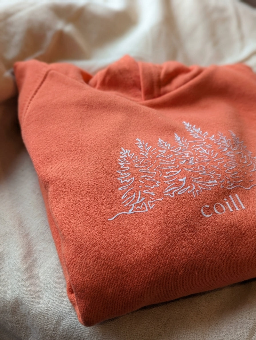 Close-up detail of trees illustration on orange hoodie