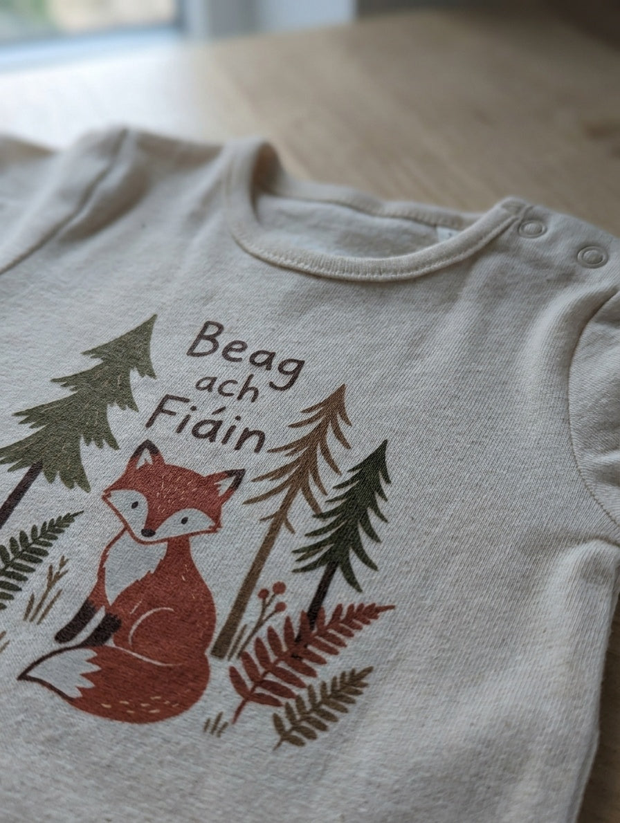 Close-up detail of beagfiain illustration on cream bodysuit