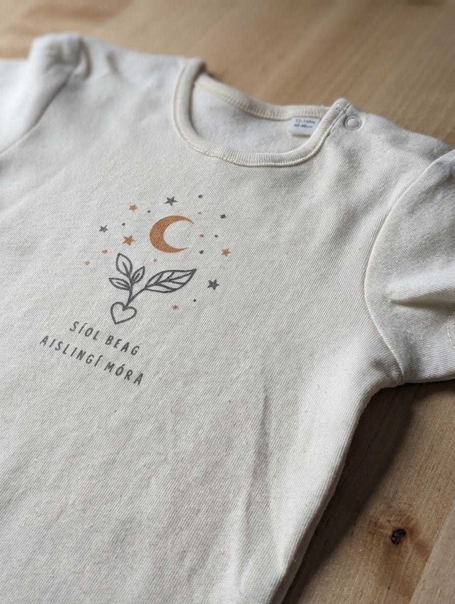 Close-up detail of seeddreams illustration on cream bodysuit