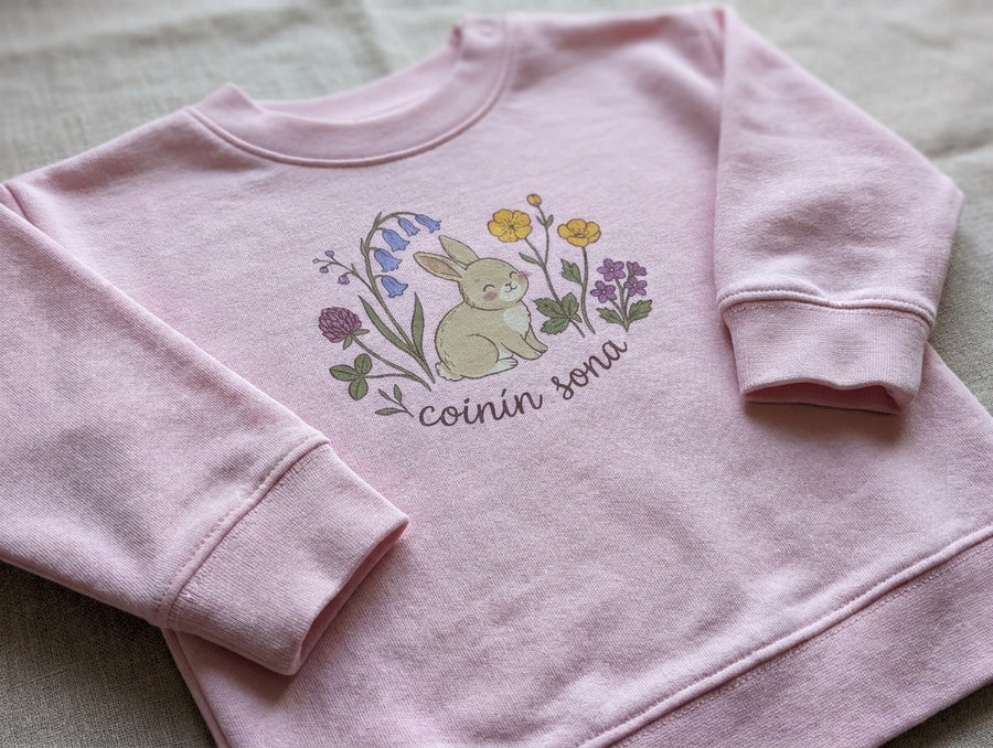 Close-up detail of rabbit-floral illustration on pink sweatshirt